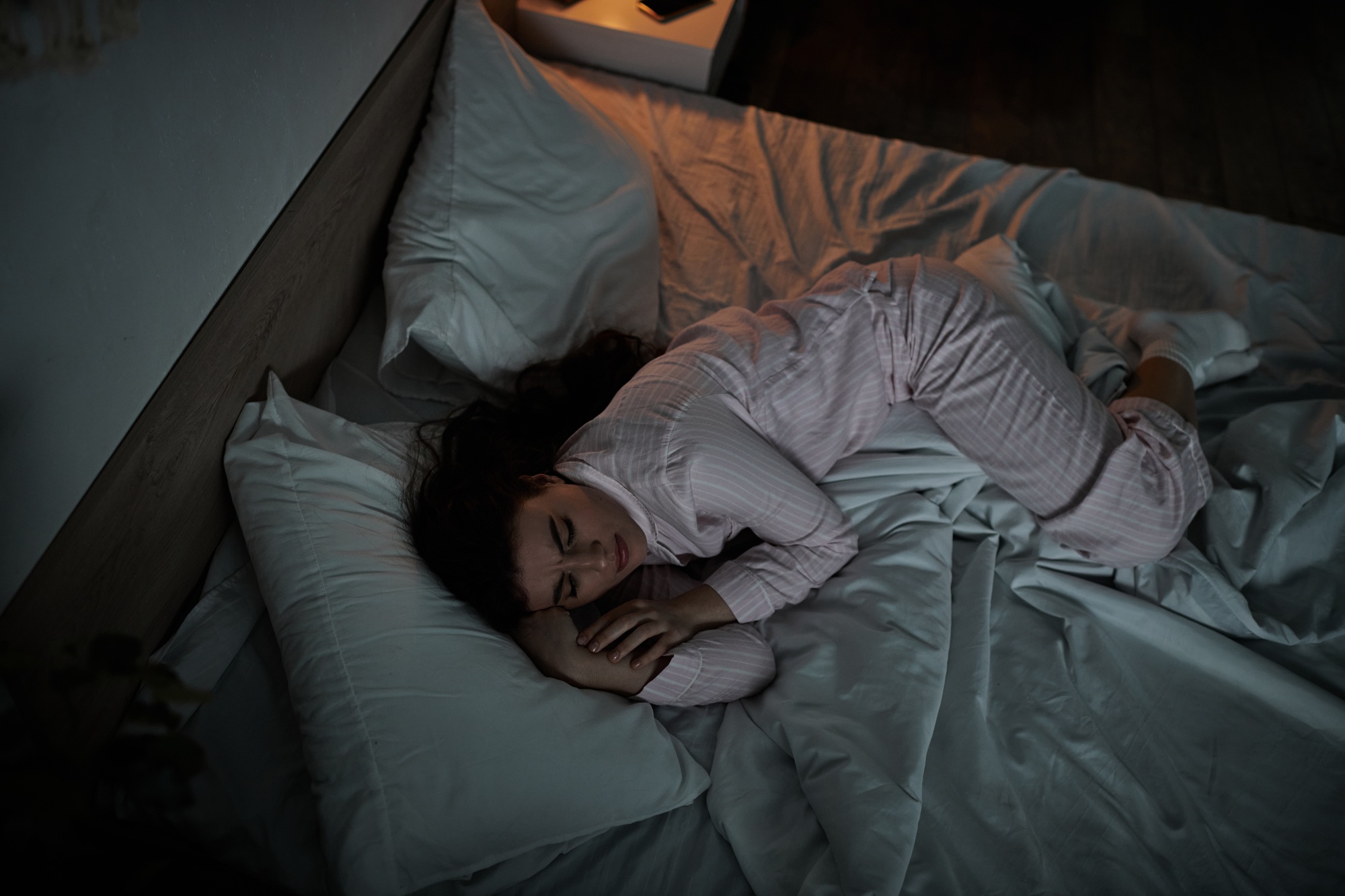 Woman curled up in bed reflecting deep emotions in the quiet of night
