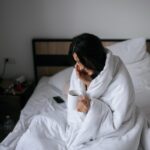 Woman wrapped in a blanket and holds a mug