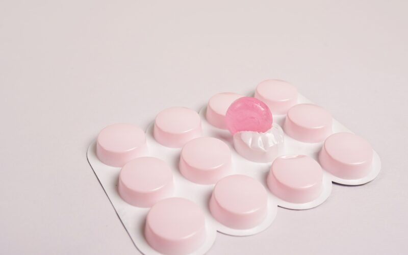 cough lozengers over white background, pink pills
