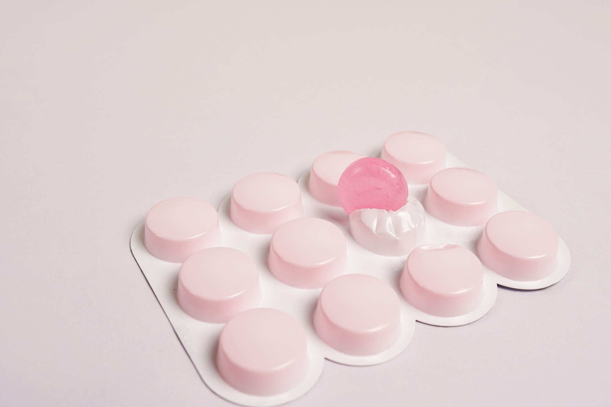 cough lozengers over white background, pink pills
